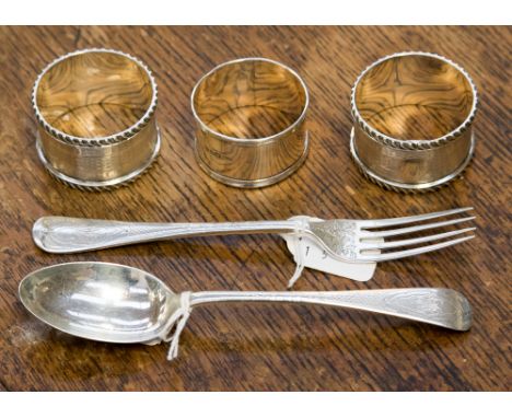 Three silver napkin rings and a Christening set, comprising spoon and fork, both with foliate engraving, Sheffield 1926, make