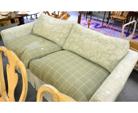 A three seater sofa in pale green floral upholstery and with green tweed stuffed over cushions