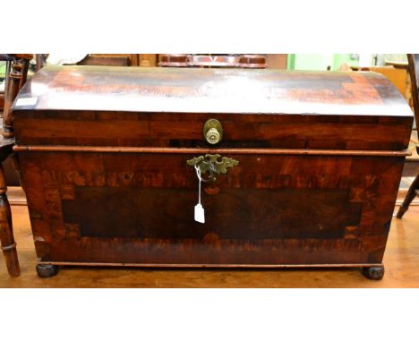 An 18th century pine lined dome top trunk, veneered in mahogany, burr yew and kingwood, with hinged lid enclosing a candle bo