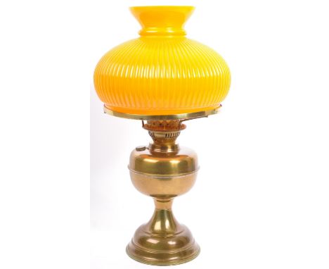 A vintage 20th Century brass orange glass oil lamp. Having a clear glass flute, bulbous orange shade with reservoir and circu