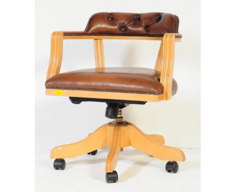 A 20th century swivel office captains chair. With raised cushioned button back rest, stud work to arm rests on tan leatherett