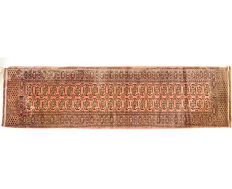 A 20th century Bokhara Tekke Turkman rug having red ground with central panel of repeating kocboynuzu and yildiz motifs with 