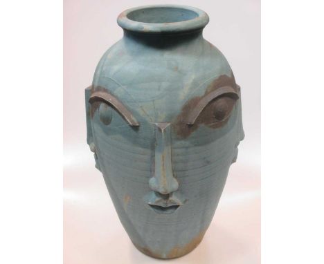 A modern ceramic vase with moulded facial features 48cm high