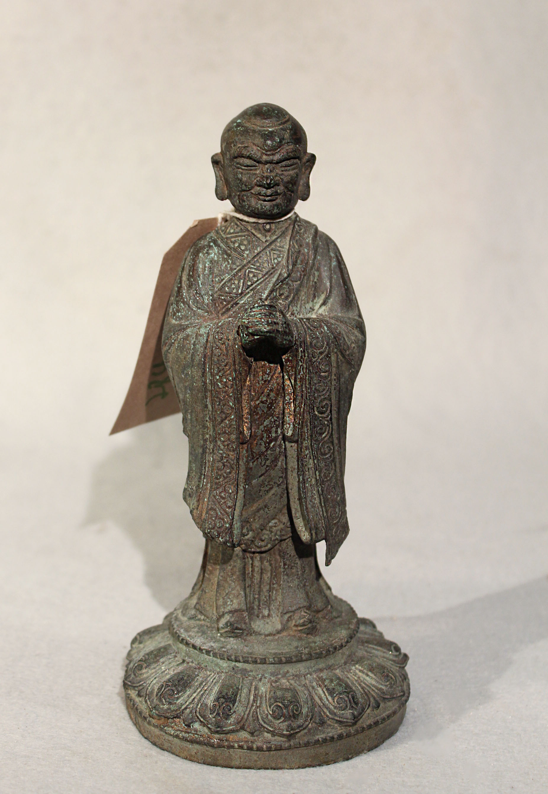A Chinese lacquered wood figure of a standing lohan, on lotus base, 62.