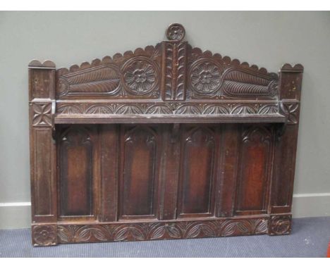 A carved oak panelled head board with triangular arched pediment and shelf 110 x 137cm