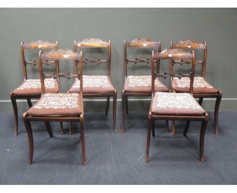 A set of six Regency faux rosewood dining chairs, with scrolled acanthus top-rails, the caned seats with floral tapestry cush