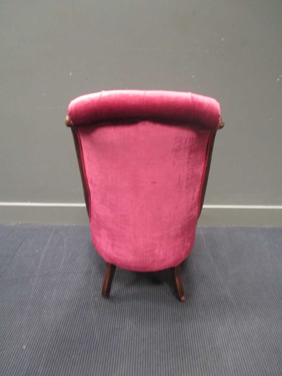 A Victorian mahogany nursing chair, with pink velvet button back