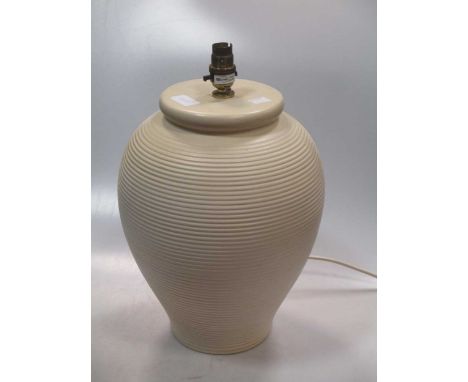 A ribbed cream coloured ceramic lamp base of ovoid form