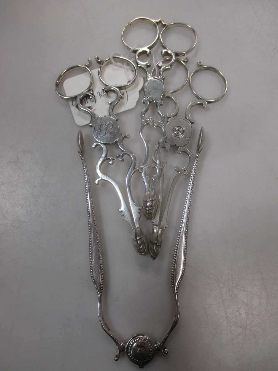 3 pairs of silver tea tongs and a pair of sprung loaded silver sugar