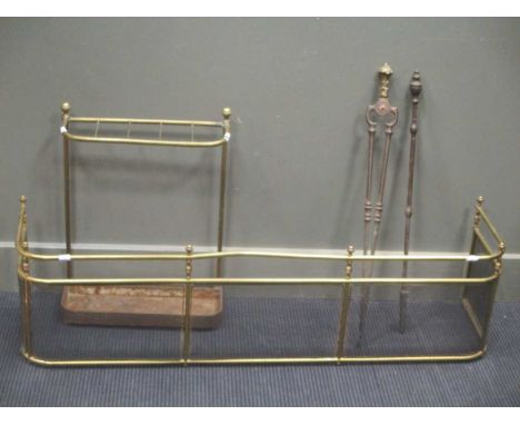 A George III brass fire fender, 122cm wide, a set of fire irons and a brass stick/umbrella stand 122cm wide (3)