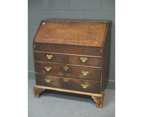 An 18th century oak and crossbanded bureau, the fall front revealving a fitted interior and well, fitted two short and two lo