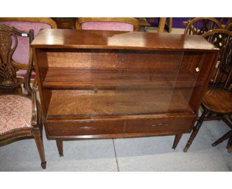 A vintage mahogany display cabinet having sliding glazed door shelf section over two drawers, with stylised handles, very nic