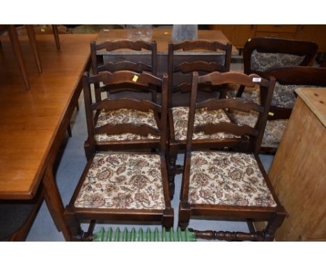 A set of four traditional oak ladder back dining chairs having upholstered seats