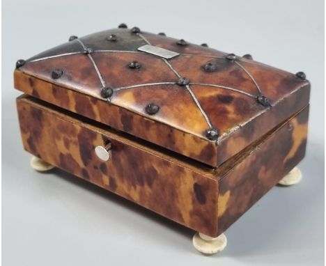 19th century tortoiseshell snuff box with metal studs and geometric stringing to the domed cover, standing on three turned iv