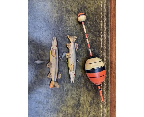 Angling: two small vintage carved and stained wood pike form decoys, 18cm long; together with a vintage fishing float. (3) 