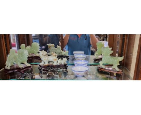 A group of three Chinese carved jade lion dogs, each on wood stand, largest 16.5cm wide; together with two famille rose tea b