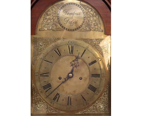 An impressive mahogany and brass mounted long case clock, having arched hood surmounted by finials, enclosing a brass spandre