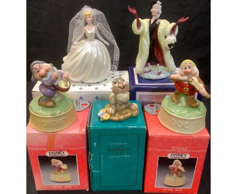 A Royal Doulton Disney figure, Cruella Deville, boxed; a Schmid Disney figure, Cinderella in Wedding Gown , boxed; a pair of 