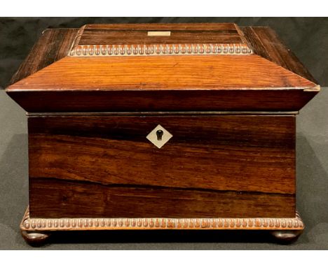 A Regency rosewood sarcophagus shaped tea caddy, mother-of-pearl vacant cartouche and escutcheon, beaded borders, four bun fe