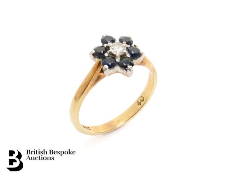 18ct yellow gold sapphire and diamond ring. The floral set ring set with a center diamond, approx 10 pts surrounded by six mi