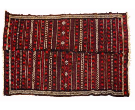 A BELOUCH BROCADED CARPET OR WALL HANGING constructed in two sections and with banded decoration and triple border, 237 x 146