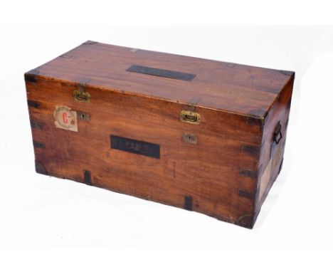 A 19TH CENTURY COLONIAL TEAK AND CAMPHORWOOD TRAVELLING TRUNK, brass bound and with hinged rising lid and side carrying handl
