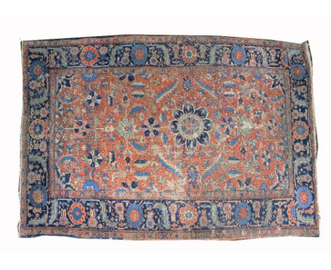 A HEREZ RUST GROUND CARPET with an all over foliate pattern in blue and apple green dyes, worn and moth damaged, 350 x 250cm