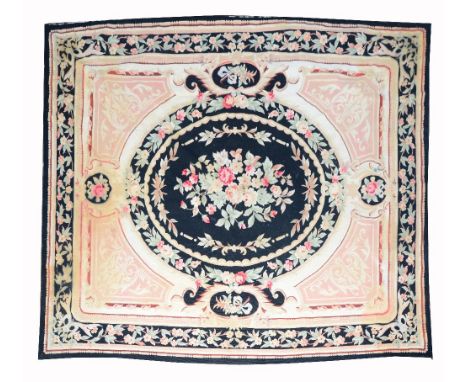 AN AUBUSSON STYLE CARPET OR WALL HANGING with a central black ground oval cartouche within a foliate border, 288 x 228cm