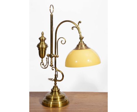 A BRASS READING LAMP of open scroll form with counter weight and glass shade, 72cm high