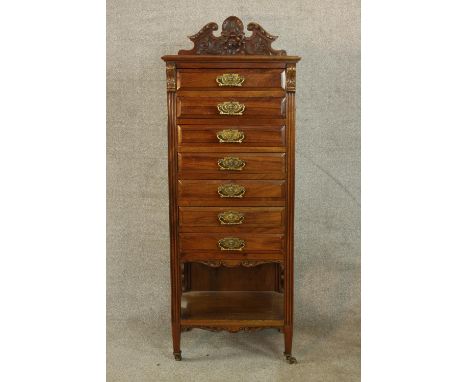 An Edwardian walnut seven drawer music/sheet music cabinet, each with brass swing handles and shelf under tier, raised on tap