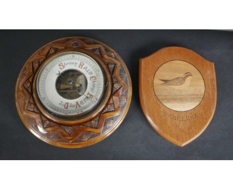 An early 20th century carved oak Barometer with enamel dial along with a marquetry shield depicting a water bird engraved St 