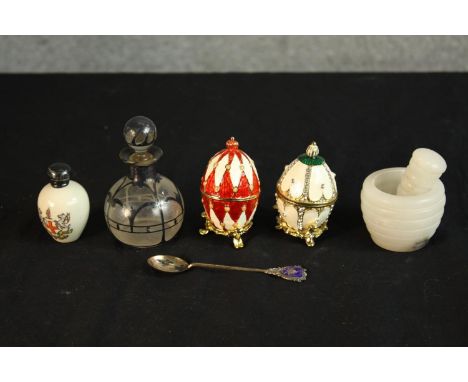 Two 20th century gilt and enamel egg ornaments, together with a small glass globular scent bottle and stopper, a hardstone pe