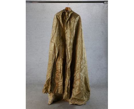 A 20th century gold silk theatrical cloak. H.180 W.80cm 