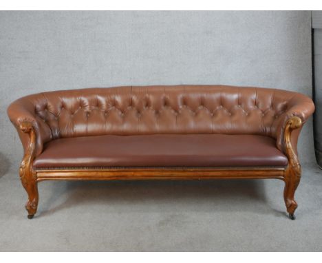 A 19th century mahogany framed brown leather button back settee raised on carved cabriole supports terminating on casters. H.