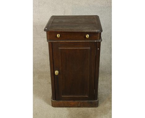 A 19th/early 20th century stained single door wash stand, the hinged lid opening to reveal a white painted ceramic basin with