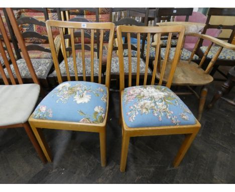 A pair of modern stick back dining chairs with blue upholstered seats 