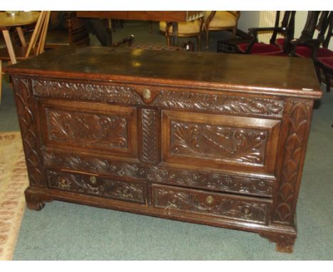 Early 19th century oak mule chest, hinged lid, carved and armorial panels over two base drawers on bracket ogee feet, height 