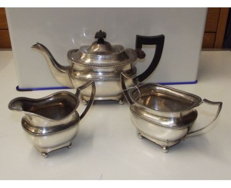 Silver three piece tea service comprising teapot, cream jug, and sugar bowl, raised handles, beadwork and gadrooning througho