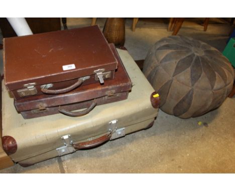 Three various suitcases; and a pouffe