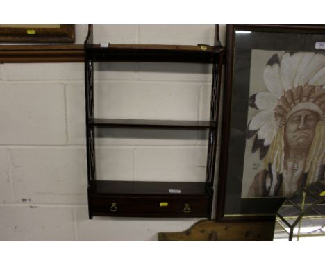 A mahogany three tier wall shelf fitted single drawer
