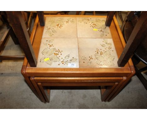 A nest of three tile top occasional tables 