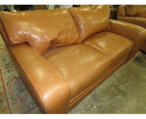 A TAN LEATHER TWO SEATER SOFA -SIGNS OF WEAR