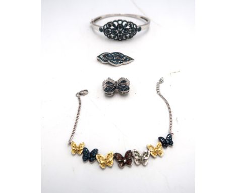 A group of silver and diamond jewellery. To include a hinged blue diamond cluster bangle, diameter 68mm stated diamond weight