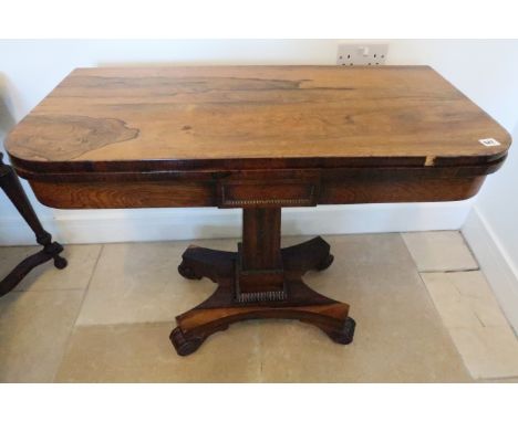 A 19th century rosewood veneered card table, folding swivel top over single column support terminating in quatrefoil base, ca