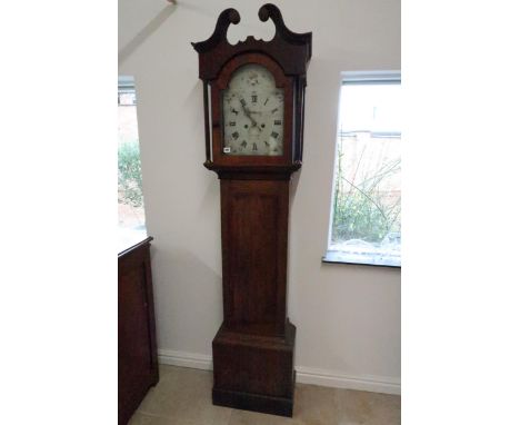 An 8 day longcase clock with a painted arched dial signed Bradley Ilkistone in an oak and mahogany case with weights and pend