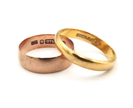 A 22ct gold band ring. Size M. Weight 3.33 grams. Together with a 9ct band ring, size K 1/2. Weight 1.69 grams