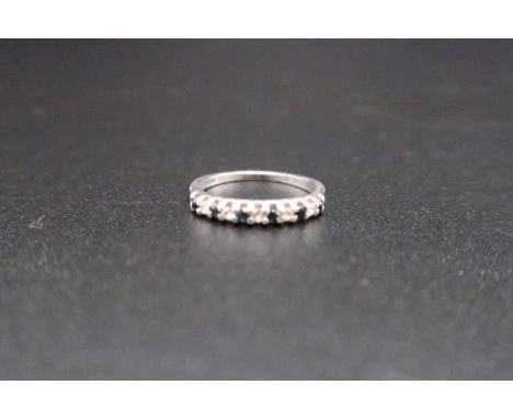 A stamped 9ct white gold eternity ring set with diamonds and sapphires - ring size K - weight approx 1.4 grams