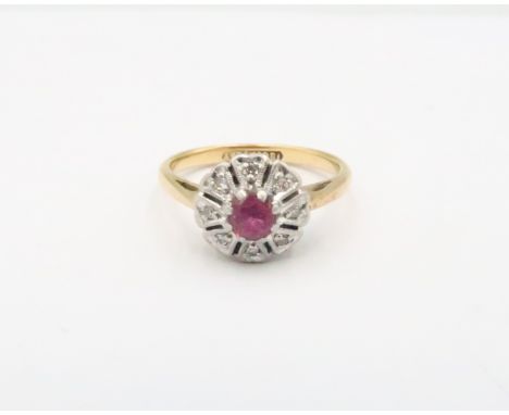 A ruby and diamond flower cluster ring. Size N 1/2. Stamped 18ct and plat. Weight 3.76 grams.