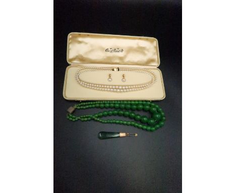 A Jade pendant, a double string of green glass beads along with a string of simulated pearls and earrings set