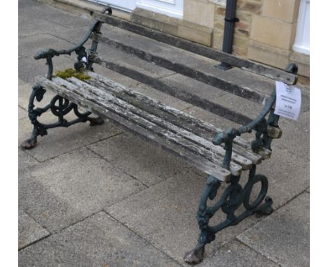 A Victorian wooden slatted cast iron garden bench with dog form arms, probably Coalbrookdale